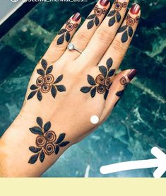 a woman's hand with black and brown designs on it