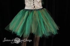 a green and silver tutule dress on display in front of a black background