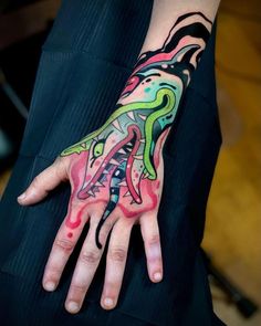 a person's hand with colorful tattoos on it