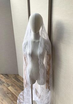 the mannequin is wearing a white lace veil