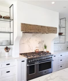 a stove top oven sitting inside of a kitchen next to white cabinets and counter tops