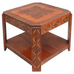 a wooden table with intricate carvings on the top and bottom shelf, sitting against a white background