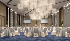 a banquet room set up with tables, chairs and chandeliers for an event