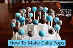 there are many chocolate covered cake pops on the white stand with blue and brown frosting