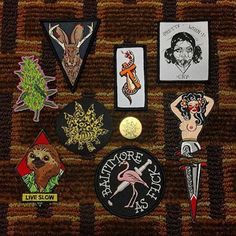 several different patches and pins on a piece of cloth