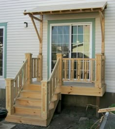 a wooden porch with steps leading up to the front door