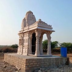 a small white building sitting on top of a dirt field