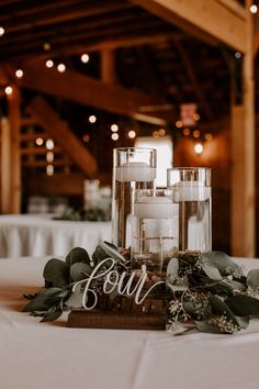 a table with candles and greenery on it in front of a sign that says four