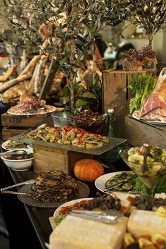 a buffet table filled with lots of different types of food and vegetables on plates next to each other