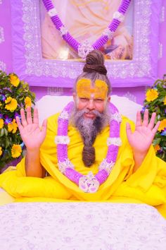 a man sitting on top of a bed with his hands in the air and wearing a yellow outfit