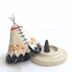 a small teepee sitting on top of a white table next to a black object