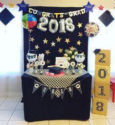 a black and white table topped with lots of decorations next to a sign that says congratulations