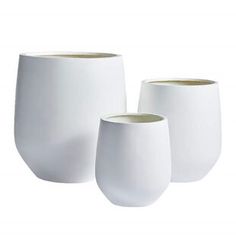 three white vases sitting next to each other