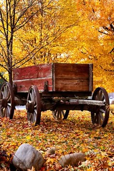 an old wooden wagon is sitting in the leaves