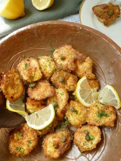 some fried food on a plate with lemon slices