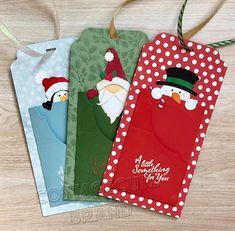 three tags with santa claus and snowmen on them