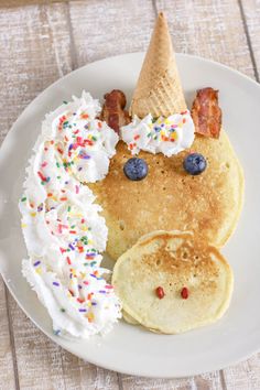 a plate with pancakes, bacon, and ice cream on it that has been made to look like a face