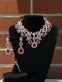 Handmade Style: Necklace and Earrings Set Material: Platinum Plated, Lab Simulated Ruby and White Sapphire Stones Imported Please Note: This necklace and earrings are sold as a set. Item Number: 6700R Evening Ruby Jewelry With Matching Earrings, Evening Ruby Jewelry Set With Matching Earrings, Formal Ruby Necklace With Matching Earrings, Teardrop Hand Set Jewelry For Evening, Hand Set Teardrop Jewelry For Evening, Elegant Ruby Jewelry Sets With Matching Earrings, Teardrop Costume Jewelry For Formal Occasions, Evening Ruby Dangle Jewelry, Formal Drop Jewelry With Jewels