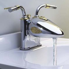 a chrome faucet with water running from it's sides and the handles