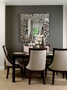 a dining room table with chairs and a mirror on the wall