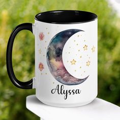 a black and white coffee mug with the name alysa on it sitting on top of a table