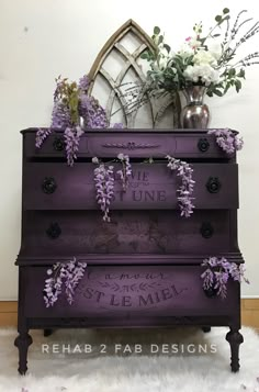 a purple dresser with some flowers on top