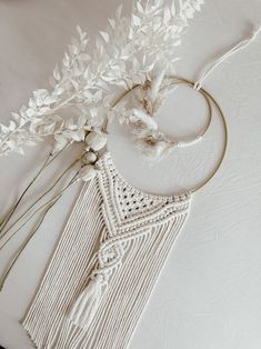 some white flowers are sitting on a table next to a piece of string and yarn