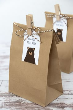 two brown paper bags with tags on them that say miss you baby much and bear much