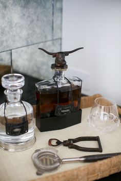 an old fashioned decanter is sitting on a tray with scissors and other items