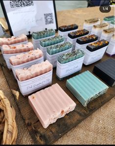 several soaps are on a wooden table with other soap bars in front of them