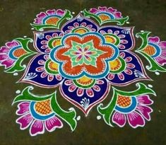 a colorful flower design is painted on the ground