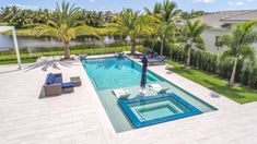 a pool surrounded by palm trees and lawn furniture