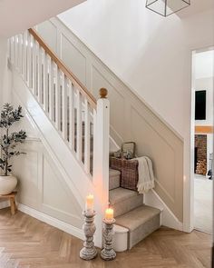 two candles are lit on the stairs in this home