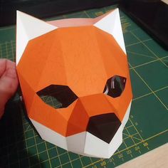 someone is making an origami tiger mask out of paper