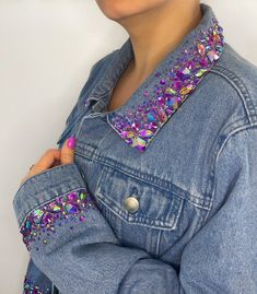 a woman wearing a denim jacket with sequins on it