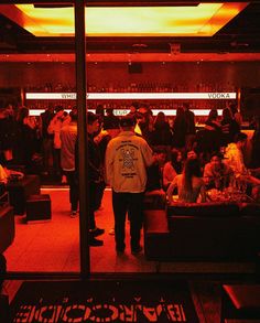 a man standing in front of a bar filled with people