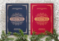 two red and blue christmas cards sitting next to each other on a wooden table with pine branches