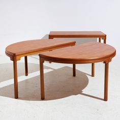 two wooden tables sitting next to each other on top of a white floor covered in light