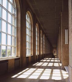 the sun shines through large windows in an old building