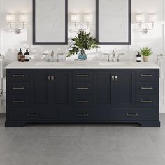 a bathroom with double sinks and mirrors on the wall next to two lights above them