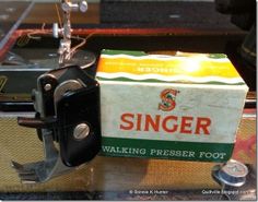 an old singer sewing machine sitting on top of a table next to a boxed box