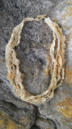 a close up of a necklace on a rock