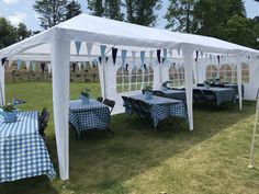 a large white tent with blue and white checkered tablecloths