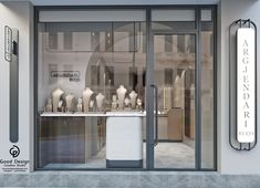 a store front with glass doors and white vases on the windows display them for sale