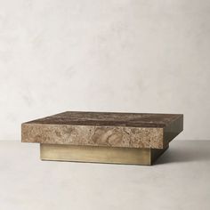 a marble and brass coffee table against a white wall