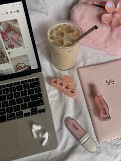 an open laptop computer sitting on top of a bed next to a cup of coffee