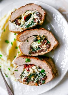 meatloaf with spinach and feta cheese served on top of mashed potatoes