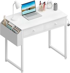 a laptop computer sitting on top of a white desk next to a lamp and other items