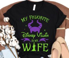 a black shirt with the words my favorite villain is my wife on it next to some cottons