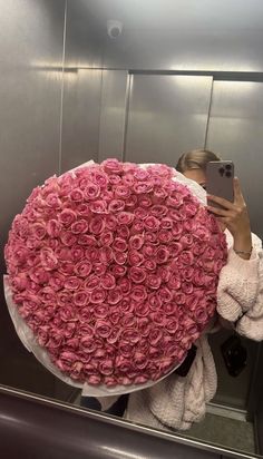 a woman taking a selfie with a giant bouquet of roses